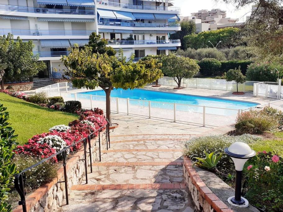 un jardin fleuri et une piscine dans l'établissement Appartement avec terrasse, piscine et garage à 400m plage, à Antibes