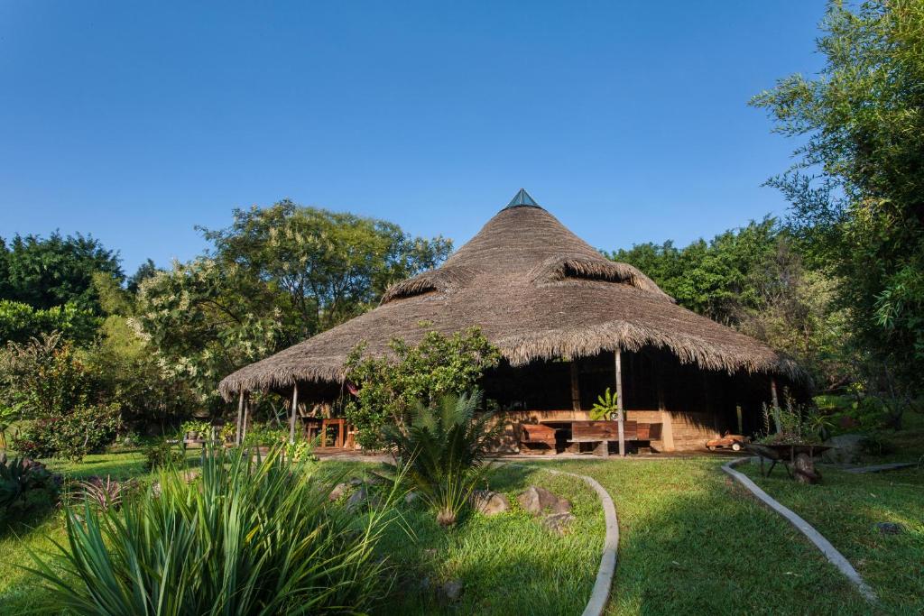 a hut with a thatched roof in a garden at Yolitia Wellness in Malinalco