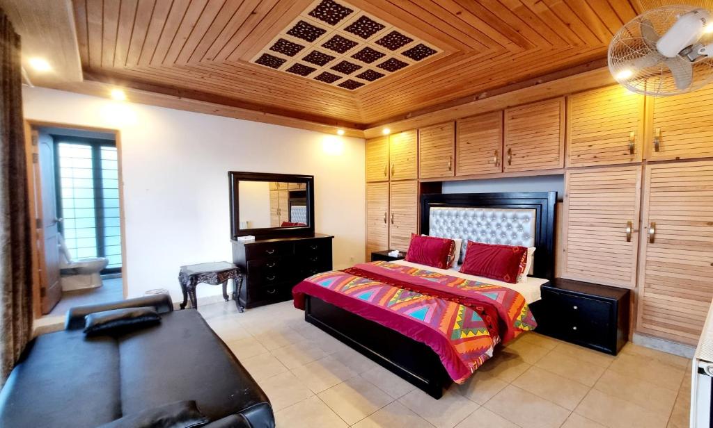 a bedroom with a bed and a couch at Haven Lodge Bhurban - Deluxe Rooms with Mountain View in Murree
