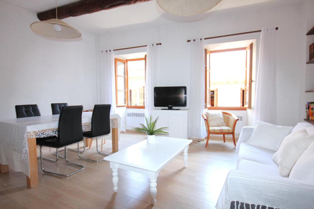 un salon blanc avec une table et un canapé dans l'établissement La Cité des Peintres, à Collioure