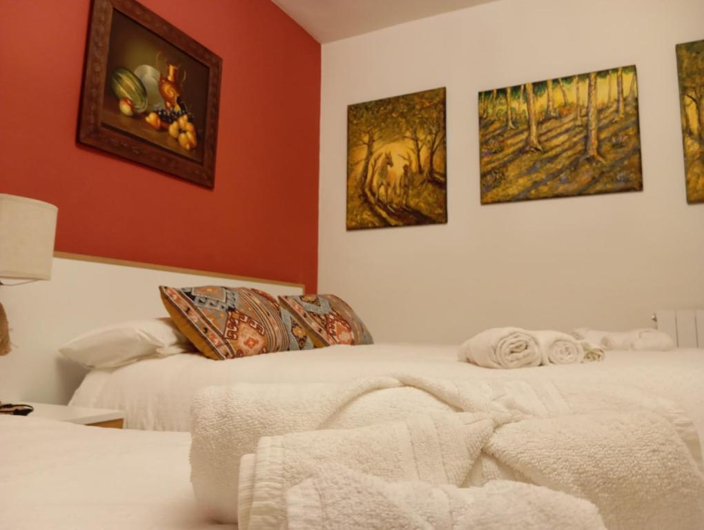Electra IndustrialにあるCasa Rural Río Fríoの壁に絵が飾られた部屋にベッドが2つある