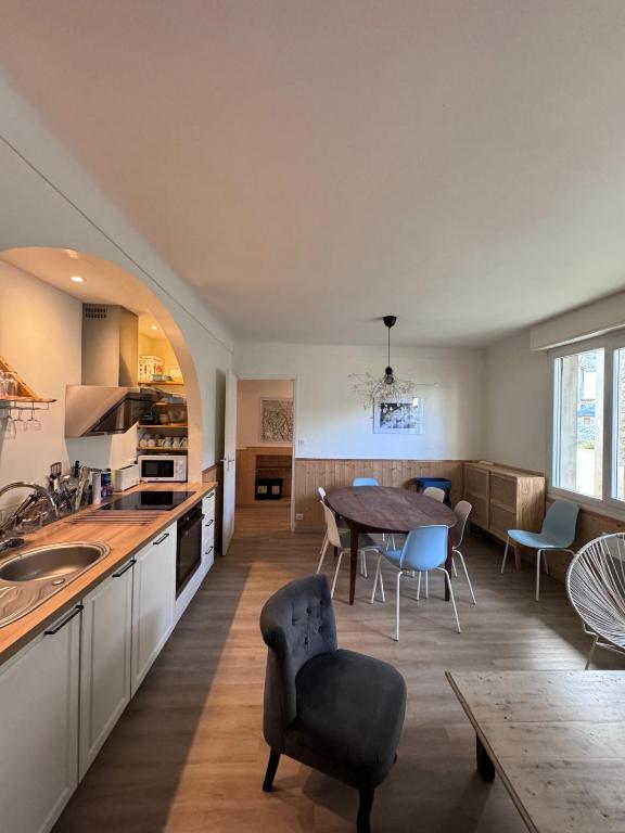 eine Küche und ein Wohnzimmer mit Tisch und Stühlen in der Unterkunft La Fontaine de St Clément in Luz-Saint-Sauveur