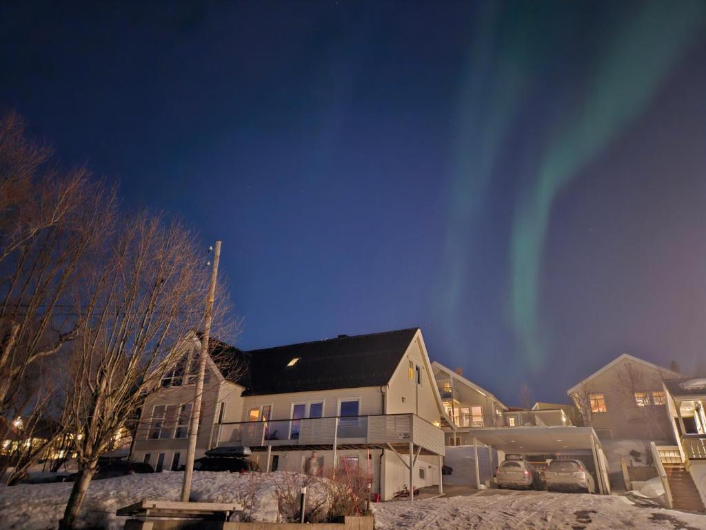 a house with snow on the ground in front of it at Small cozy 3 bed appartment in Tromsø