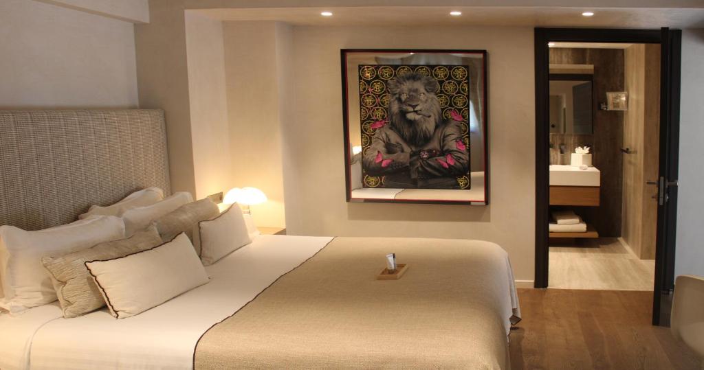 a bedroom with a large bed with a painting on the wall at Villa Cosy, hotel & spa in Saint-Tropez