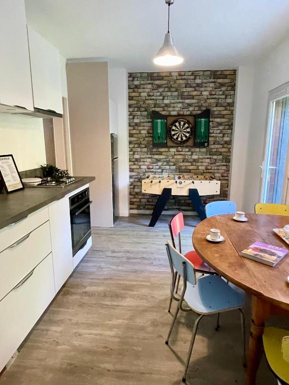 une cuisine et une salle à manger avec une table et des chaises dans l'établissement La Belle Donne maison 6 personnes baby foot PS4 - ventilateurs, à Pontcharra
