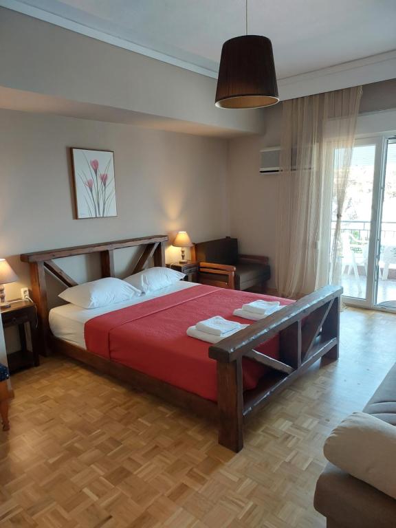 a bedroom with a large bed with a red blanket at Spyros Studio in Paleo Tsifliki