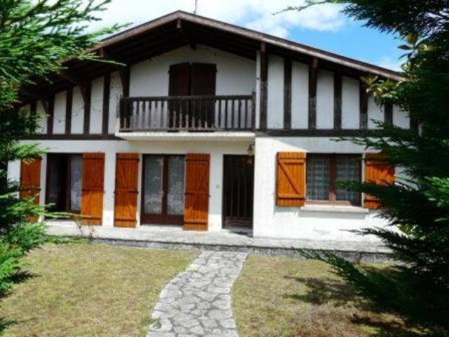 une maison avec des portes orange et blanches et une cour dans l'établissement Maison de famille, à La Teste-de-Buch