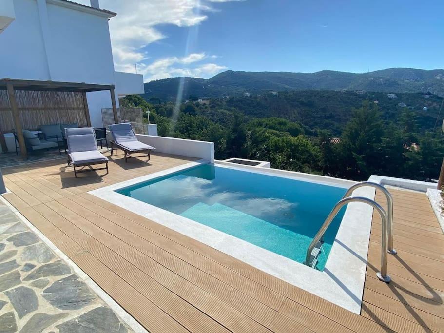 a swimming pool on a deck next to a house at Villa Libra-Skiathos in Skiathos Town