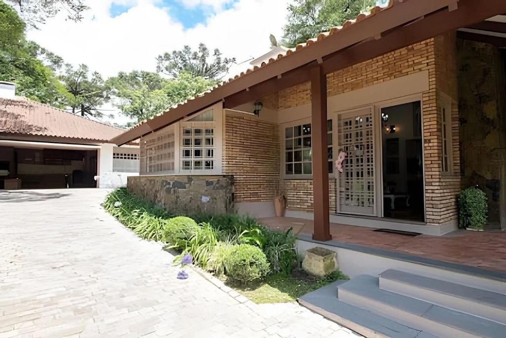 a brick house with a porch and a patio at Rosa Casa Jardim da Serra in Canela