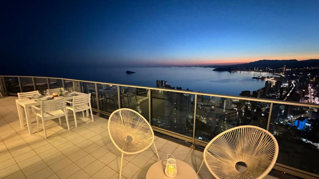 uma varanda com mesa e cadeiras e vista para a cidade em Highest penthouse with best skyline & sea views em Benidorm