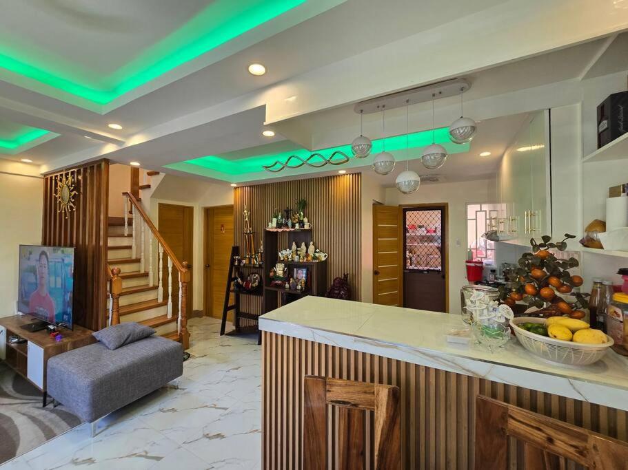 a living room with a kitchen with green lights at Family Friendly House in Malolos