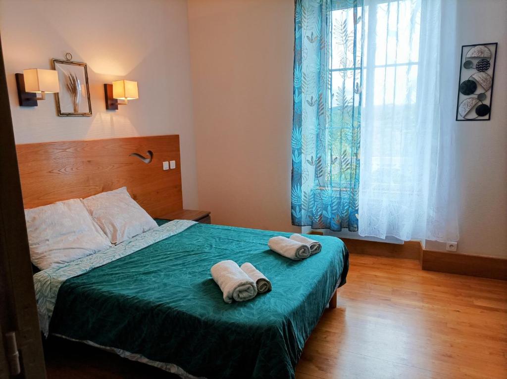 a bedroom with a bed with two towels on it at Auberge de Mourjou in Mourjou