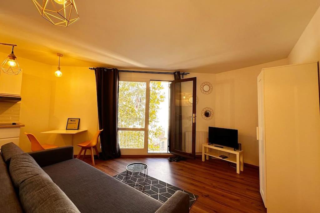 un salon avec un canapé et une télévision dans l'établissement Charmant Studio Moderne et lumineux 1min gare, à Marseille