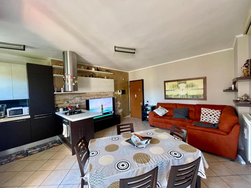 una cucina e un soggiorno con un tavolo e un divano di Casa BERTO Anagnina a La Romanina