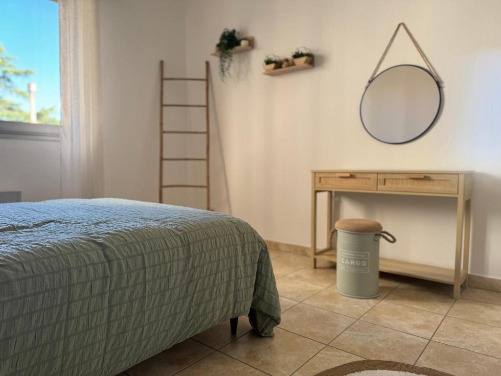 une chambre avec un lit, un miroir et une table dans l'établissement Le botaniste, à Perpignan