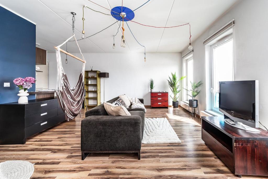 a living room with a couch and a flat screen tv at Top floor near ferry terminal - free parking in Tallinn