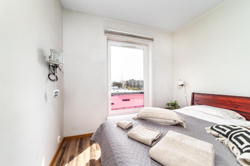 a bedroom with a bed with pillows and a window at Top floor near ferry terminal - free parking in Tallinn