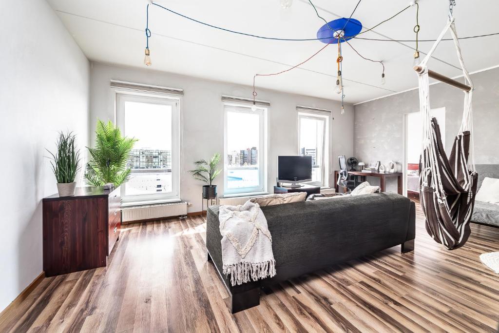 a living room with a couch and some windows at Top floor near ferry terminal - free parking in Tallinn