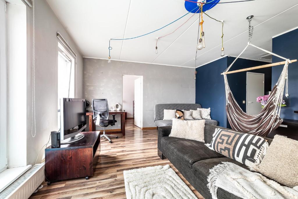 a living room with a couch and a tv at Top floor near ferry terminal - free parking in Tallinn
