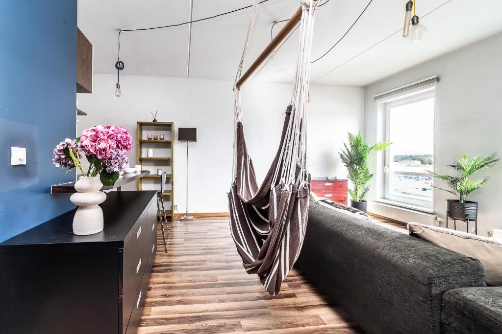 a hammock hanging in a living room with a couch at Top floor near ferry terminal - free parking in Tallinn