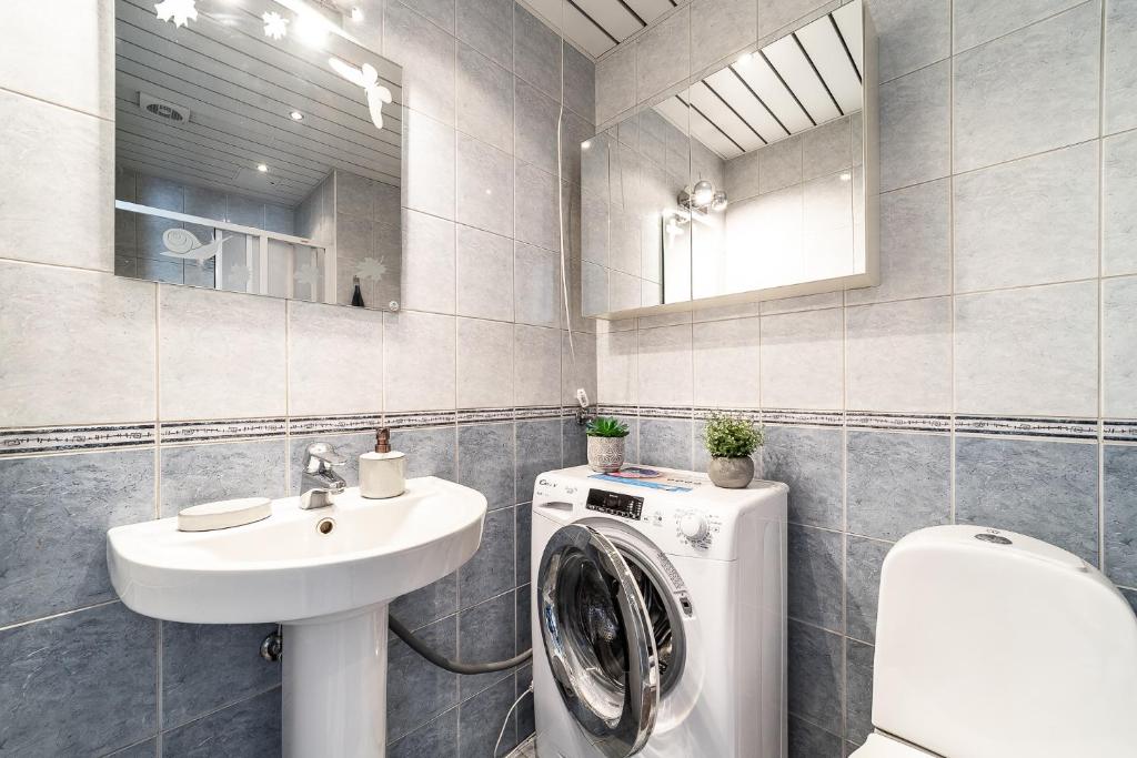 a bathroom with a washing machine and a sink at Top floor near ferry terminal - free parking in Tallinn