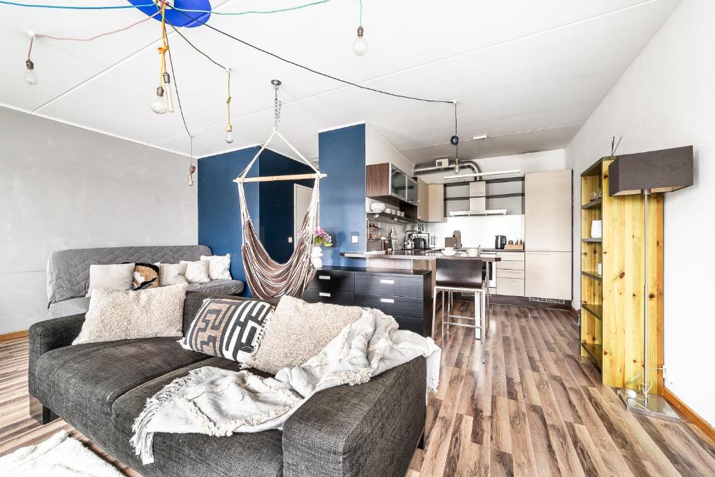 a living room with a couch and a kitchen at Top floor near ferry terminal - free parking in Tallinn