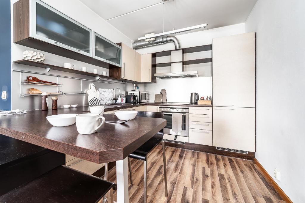 a large kitchen with a wooden counter top at Top floor near ferry terminal - free parking in Tallinn