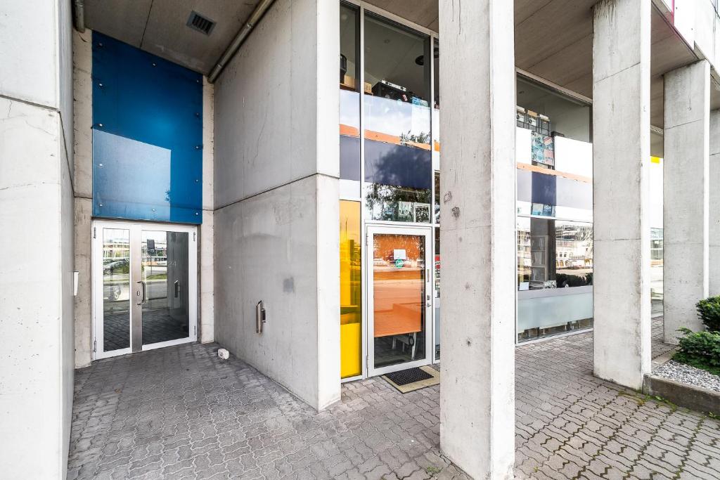 a building with large glass windows with a yellow at Top floor near ferry terminal - free parking in Tallinn