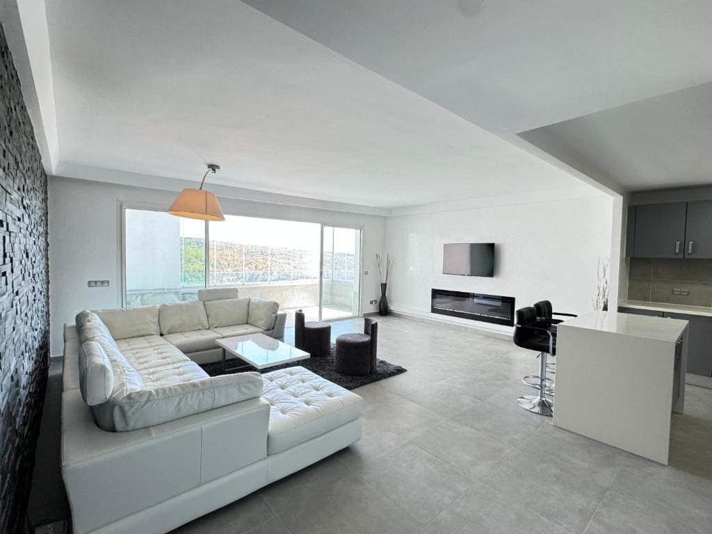 a white living room with a couch and a table at Meditranee Sea View in Tangier