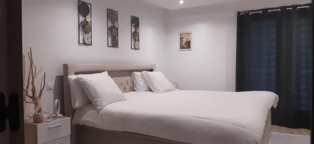 une chambre avec un lit avec des draps blancs et des oreillers dans l'établissement Chambre d'hôtes, à Menton