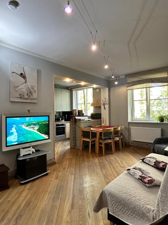a living room with a television and a dining room at Andrea Apartamenti in Jūrmala
