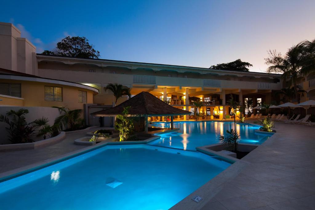 a swimming pool in front of a building at night at Sugar Bay Barbados - All Inclusive in Bridgetown