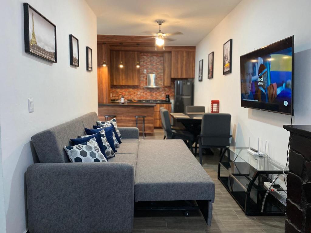 a living room with a couch and a dining room at Casa Fer Para 8 Personas Cerca de playa San Blas in Tepic
