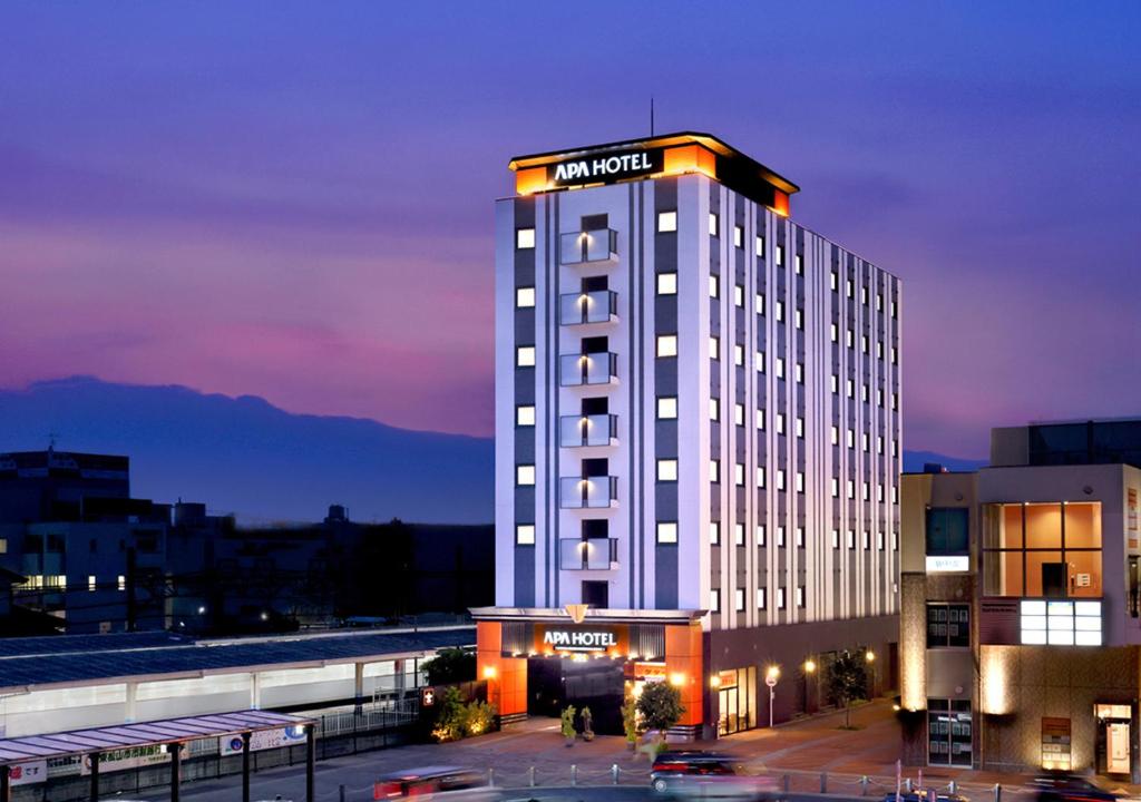 a hotel building with a sign on top of it at APA Hotel Saitama Higashimatsuyama Ekimae in Higashimatsuyama