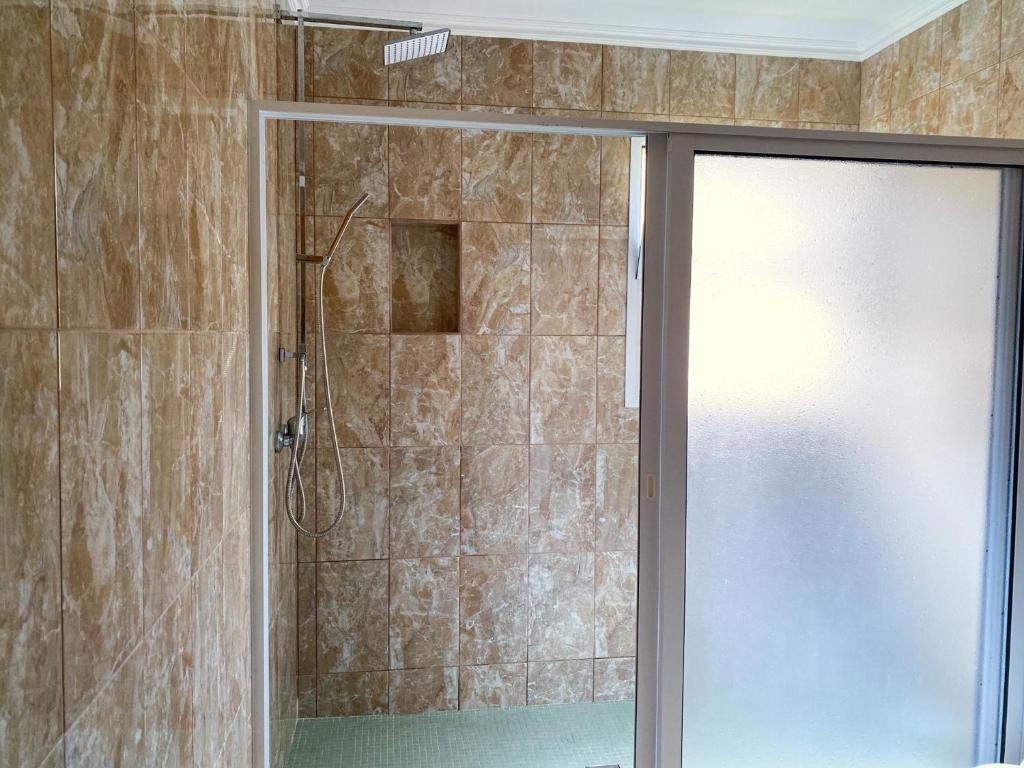 a shower with a glass door in a bathroom at Sea House in Povoação