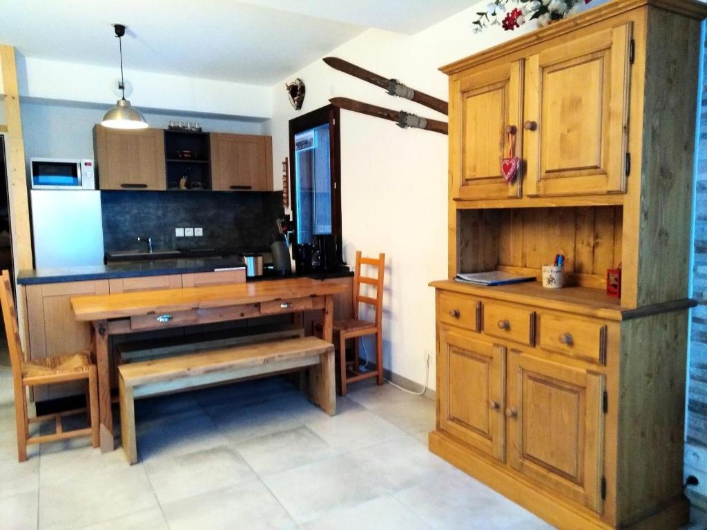 une cuisine avec des placards en bois et un bureau en bois dans l'établissement Résidence Lodges 1970 - Résidences LES LODGES 1970 N°B302 MAE-1521, à La Plagne Tarentaise