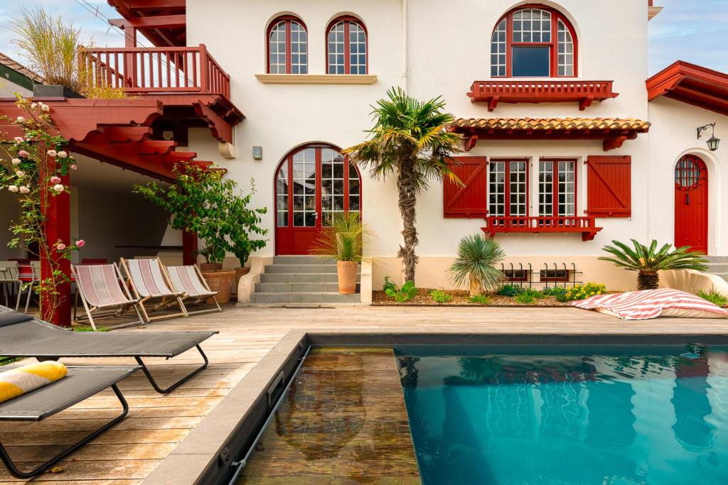 une maison avec une piscine devant une maison dans l'établissement VILLA FLOW KEYWEEK - heated pool garden Biarritz, à Biarritz