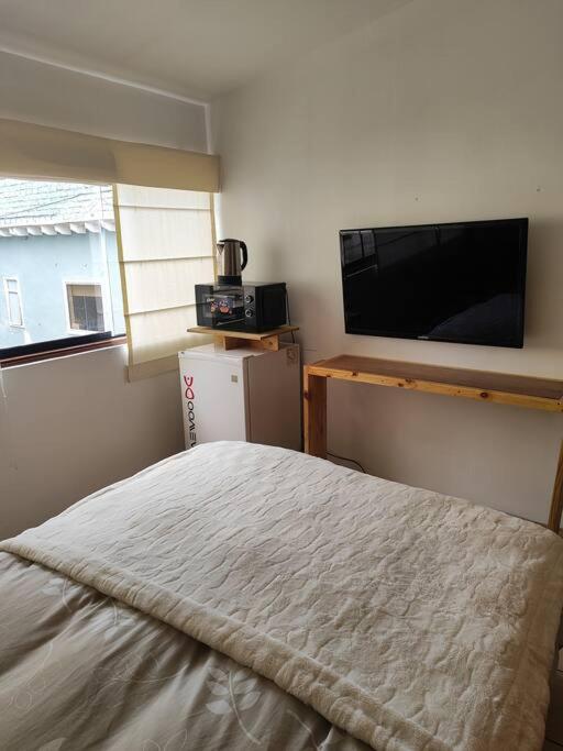 a bedroom with a bed and a flat screen tv at Cómoda habitación independiente Miraflores in Lima