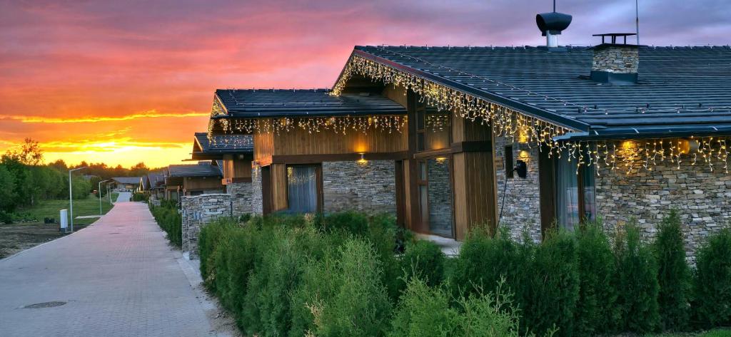 a house with a pathway next to a building with a sunset at Villa Pirin Golf in Bansko