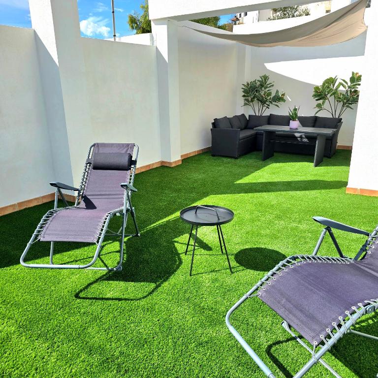 two chairs and a table on green grass at Casa Serena Alojamiento Rural in Enix