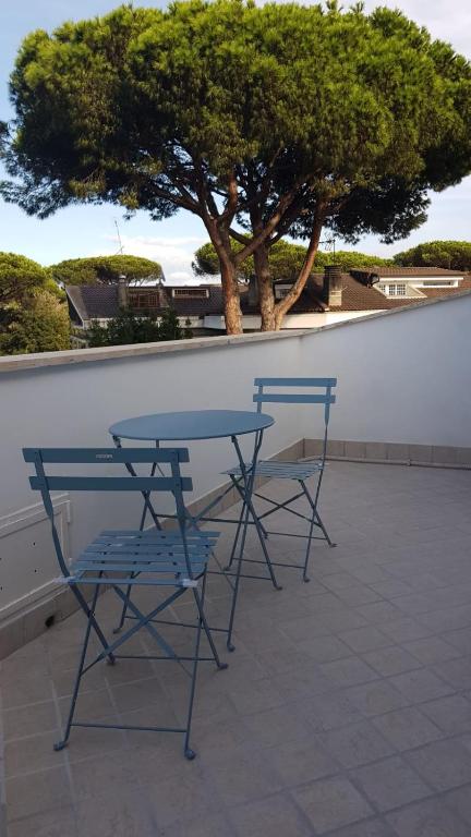two blue chairs and a table and a tree at Roma - Casalpalocco - Amipsia in Casal Palocco