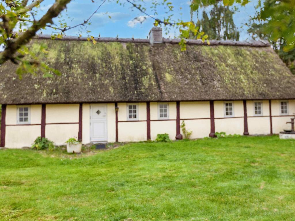 an old house with a thatched roof and a yard at 4 person holiday home in Læsø-By Traum in Læsø