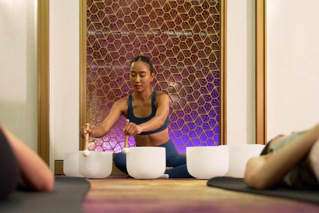 A guided sound session with bowls in a patterned wellness room.