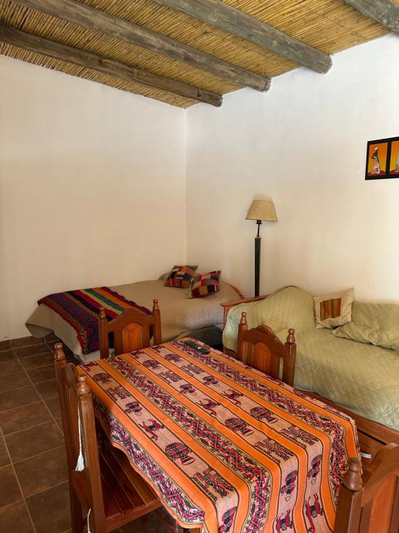 a bedroom with a bed and a couch in it at Cabaña la Viña in Purmamarca