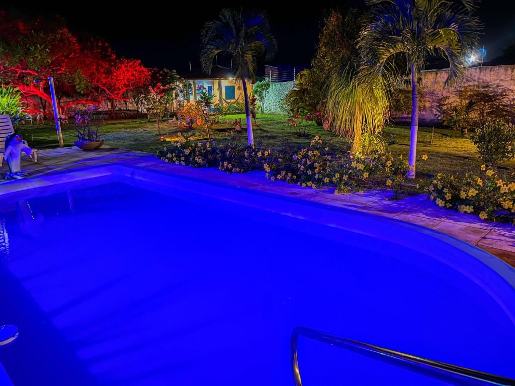 una piscina blu in un cortile di notte di Casa Lagoa Redonda a Pirambu
