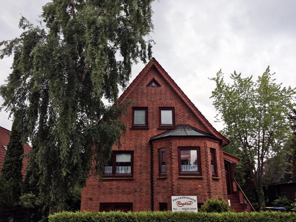 a red brick house with a tree in front of it at Raphael - "Marilyn Monroe" in Timmendorfer Strand