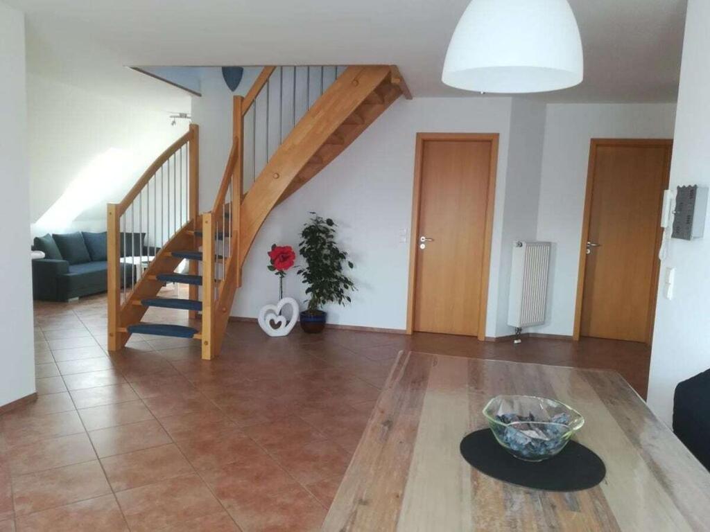 a living room with a staircase and a table at Tromm - Blick Comfortable holiday residence in Rimbach