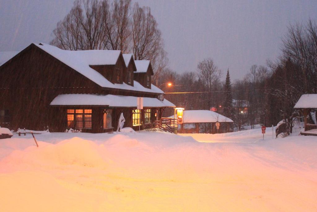 uma casa coberta de neve na frente em Auberge Micro-Brasserie Le Baril Roulant em Val-David