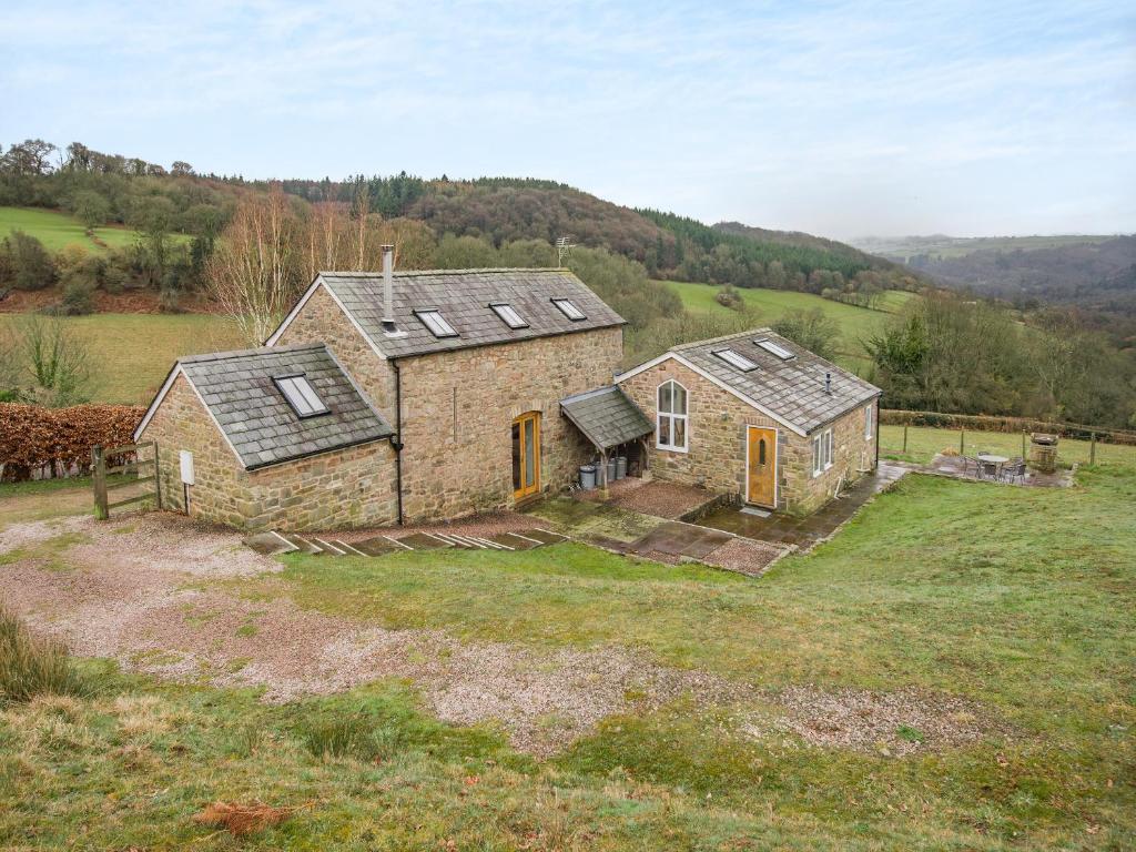 an old stone house in a field of grass at Hopewell Barn in Hewelsfield