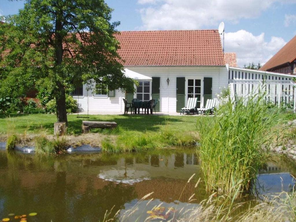 a white house with a pond in front of it at Brentel family Comfortable holiday residence in Vehlin